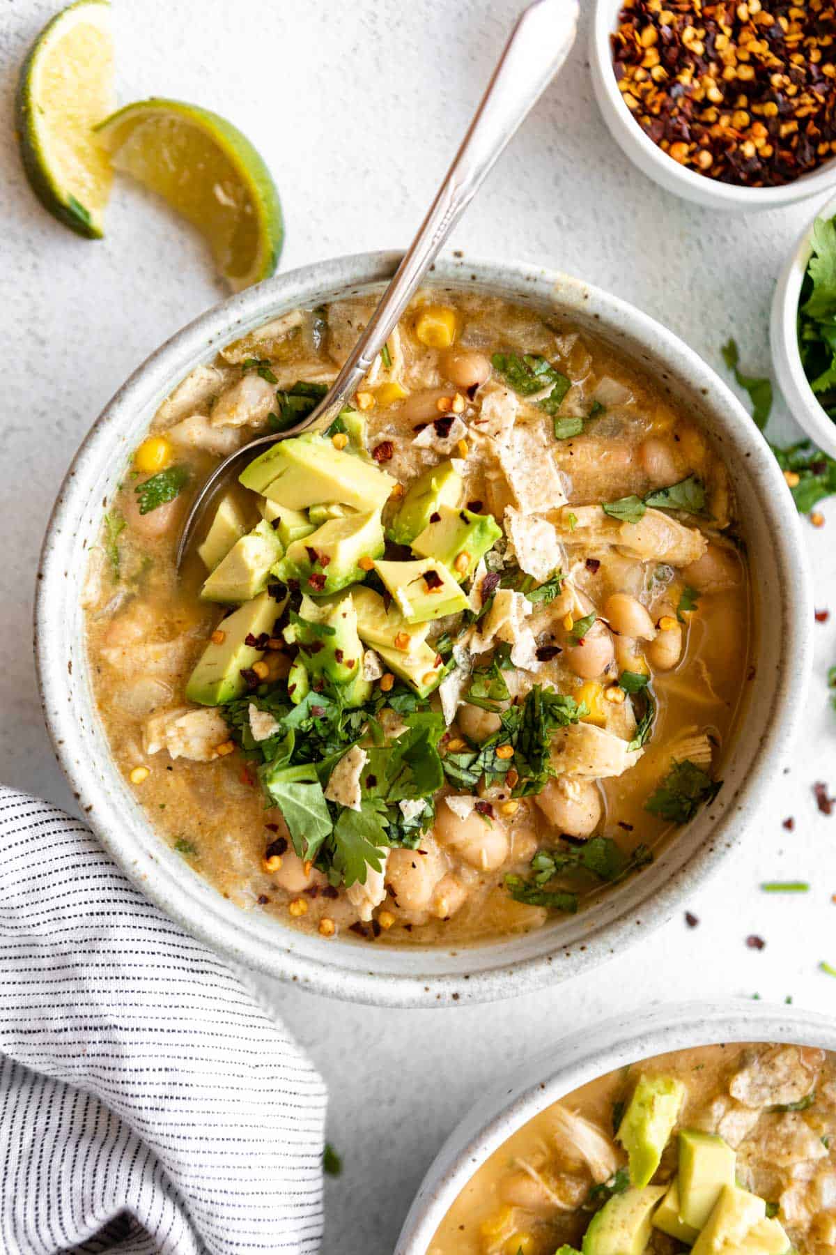 white bean chicken chili in a bowl with cilantro and chips on top