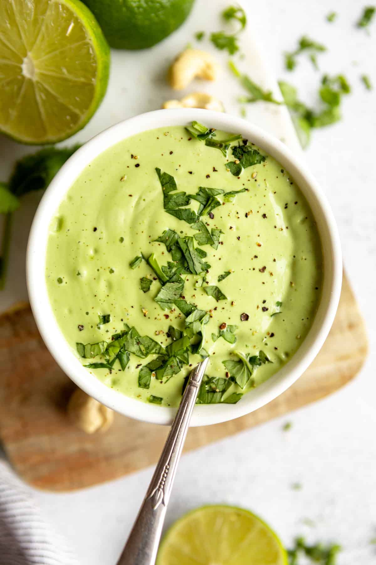 cilantro lime cashew crema in a bowl with a spoon on the side
