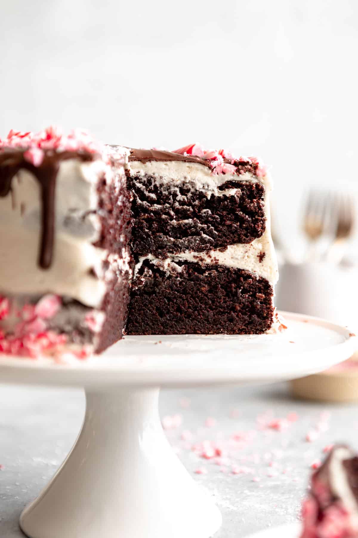gluten free chocolate peppermint cake on a cake stand with a slice cut out