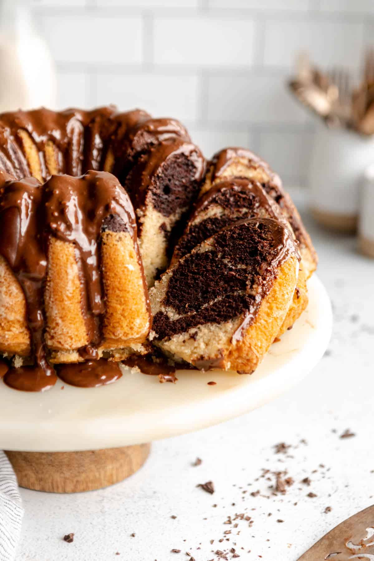 gluten free bundt cake on a cake stand with slices cut out