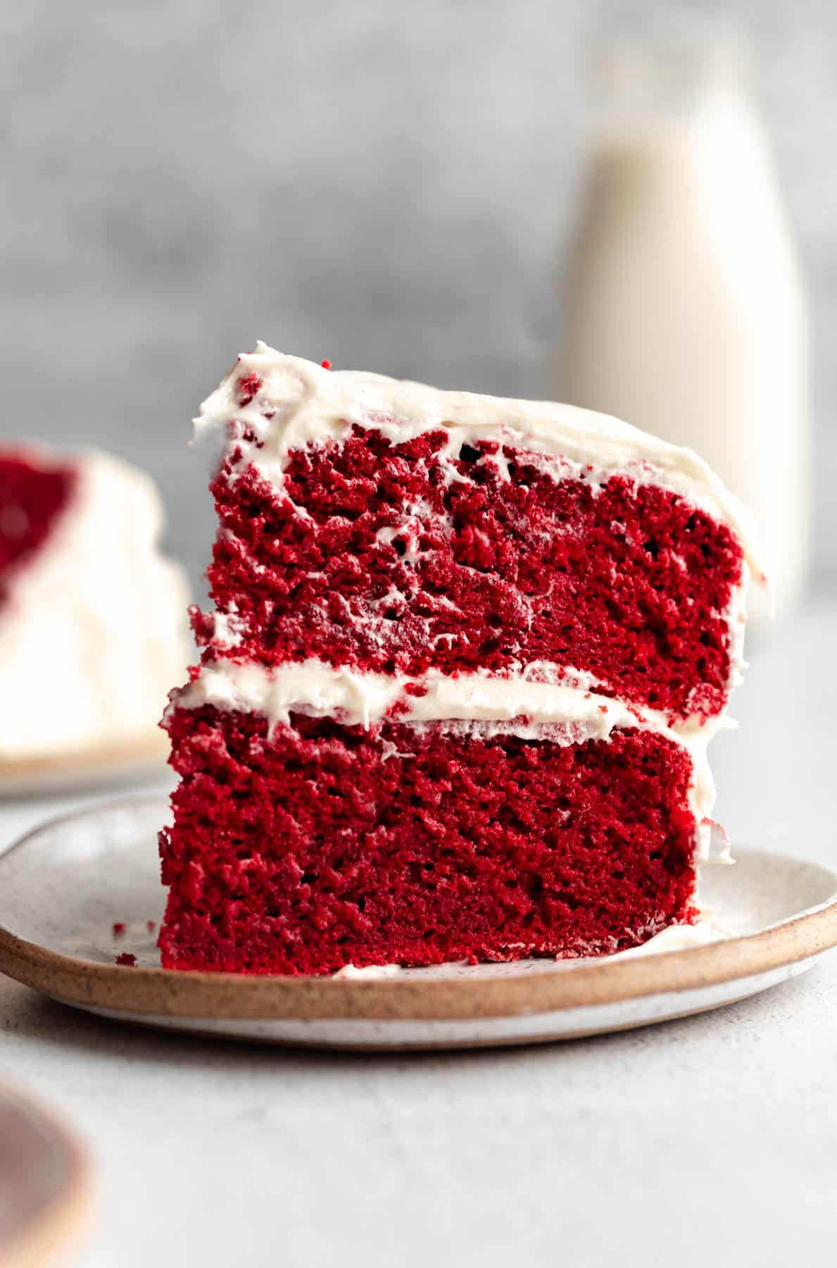 gluten free red velvet cake on a plate with milk in the back