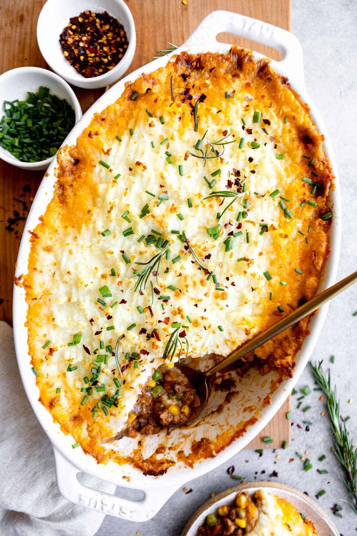 gluten free shepherds pie in a baking dish with a spoon on the side