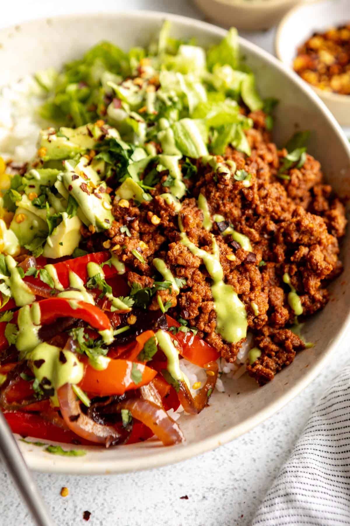 ground beef in a bowl with other taco veggies and sauce