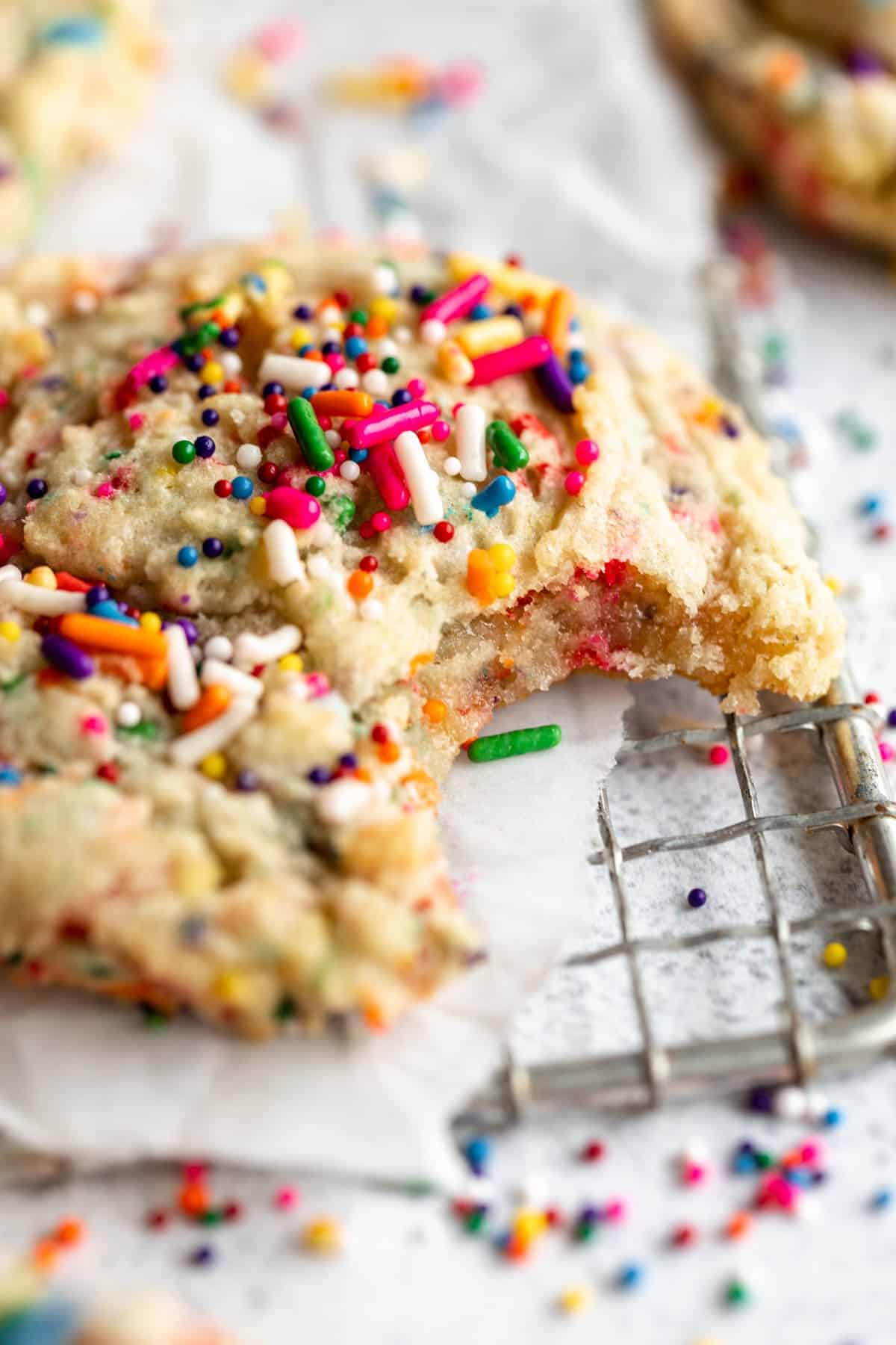 vegan gluten free sugar cookies with a bite taken out with sprinkles