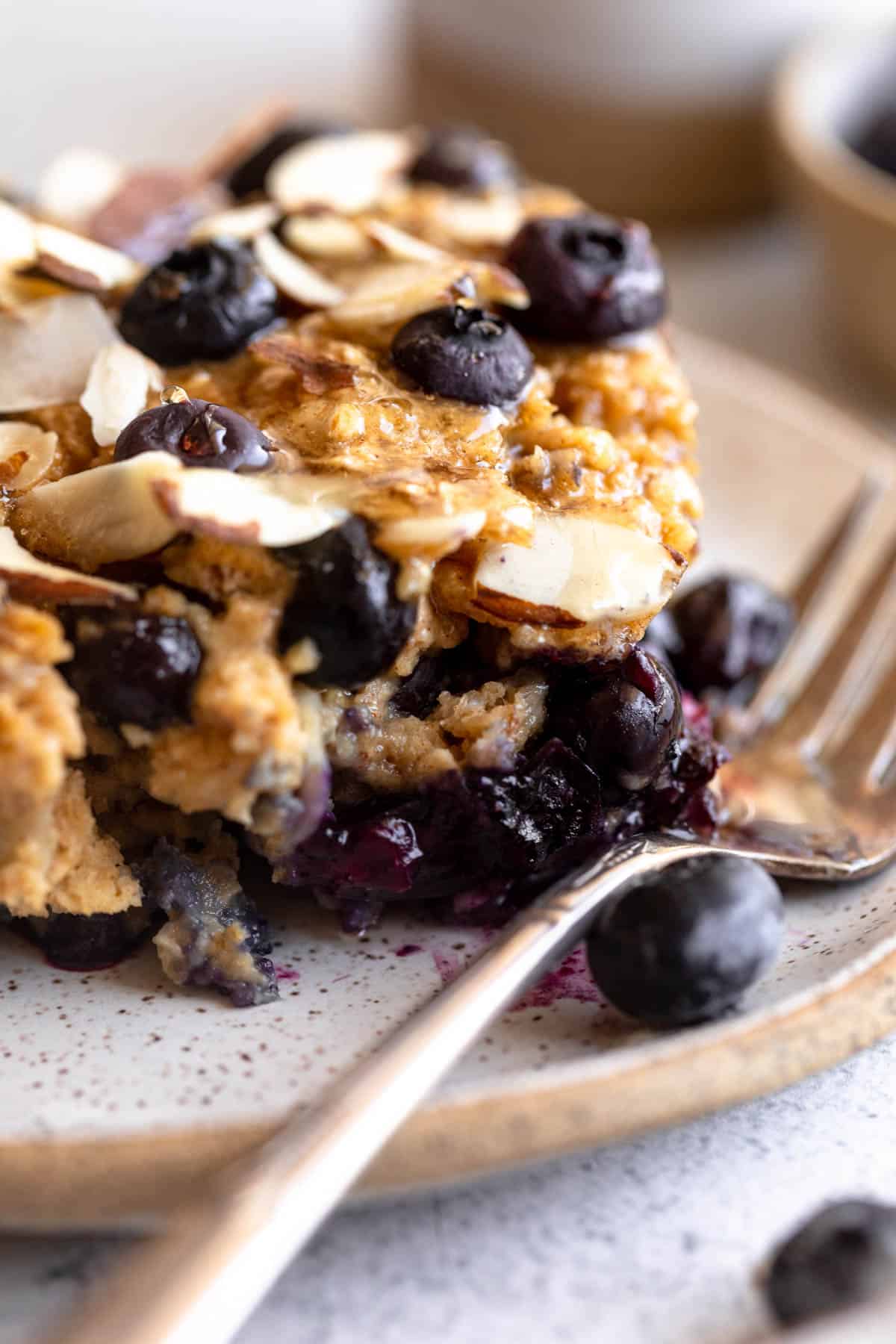 slice of the blueberry baked oatmeal on a plate with a fork