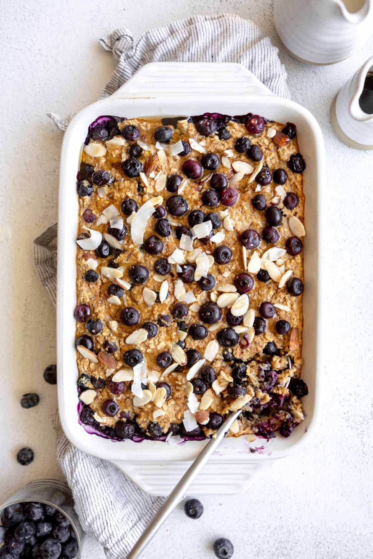 blueberry baked oatmeal in a baking dish with a spoon on the side