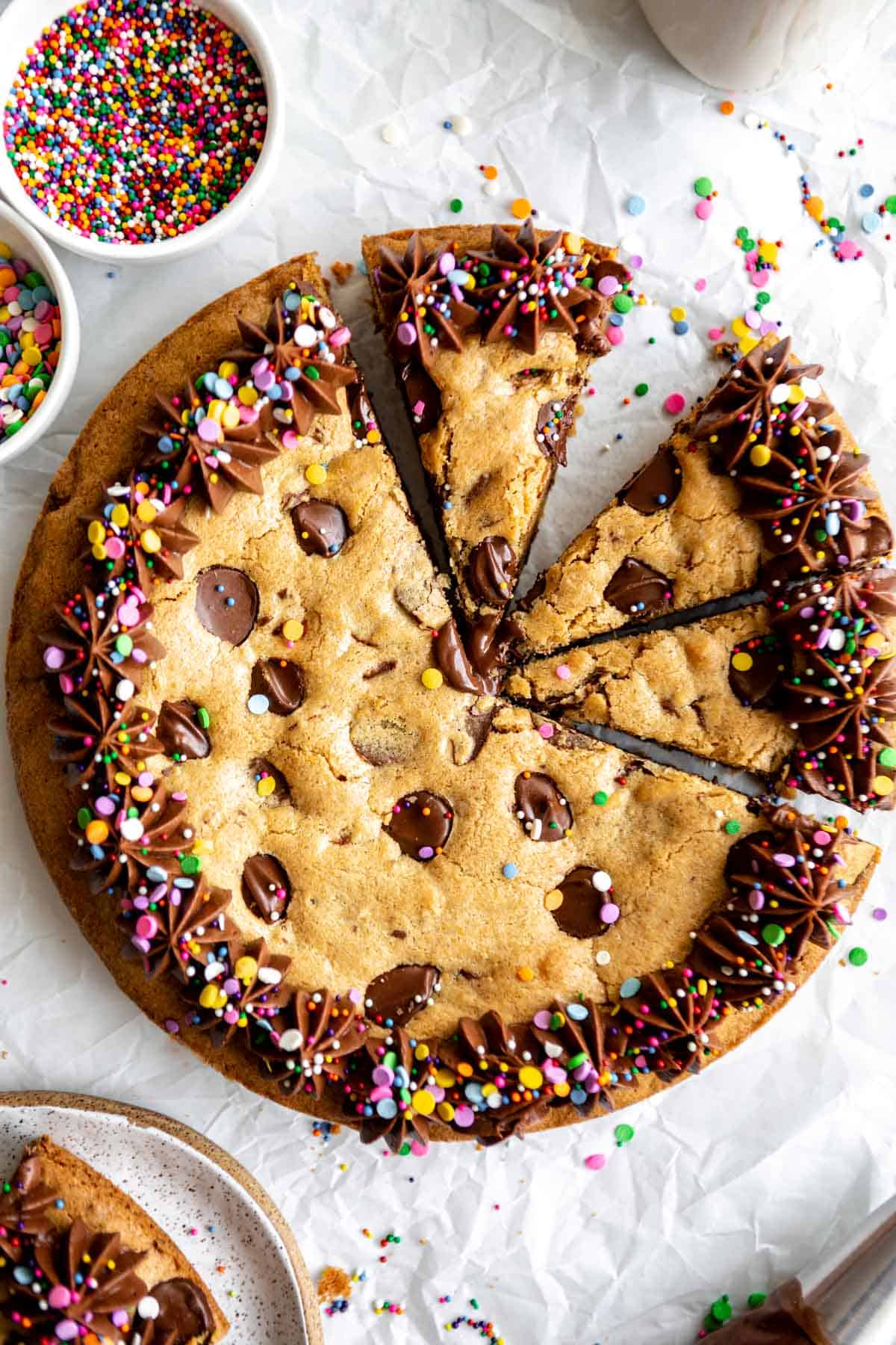gluten free cookie cake on parchment paper with frosting and sprinkles