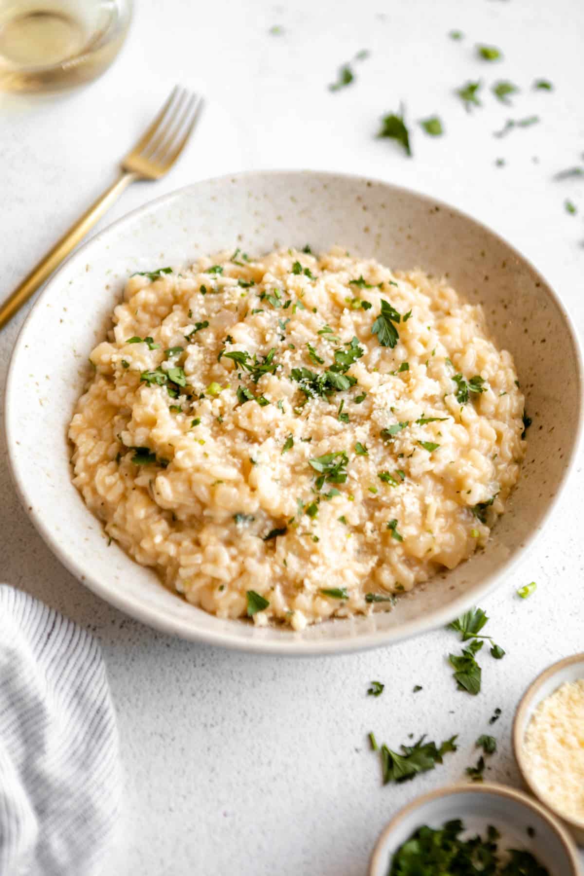 gluten free risotto in a bowl with herbs and parmesan