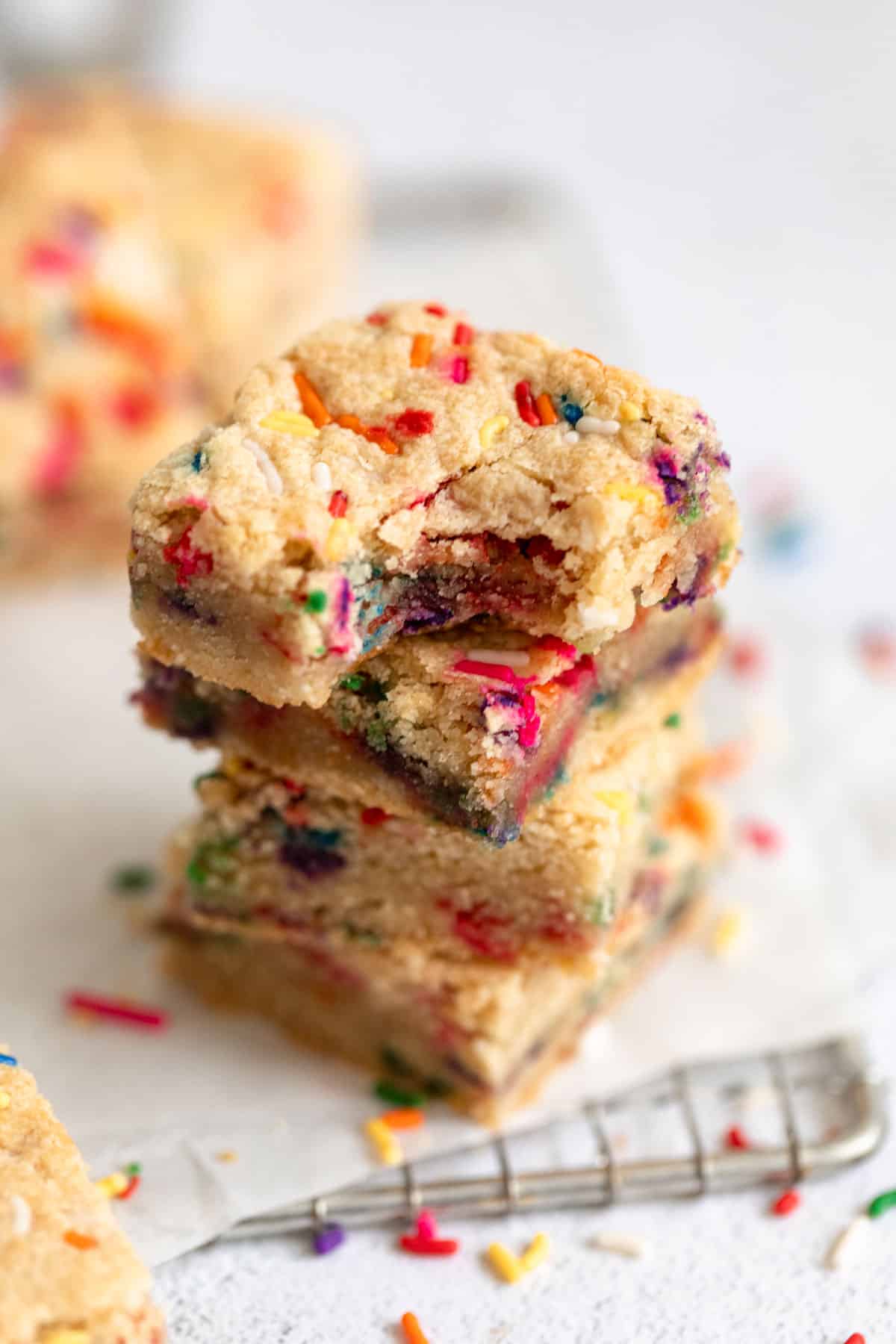 vegan funfetti blondies stacked with a bite taken out