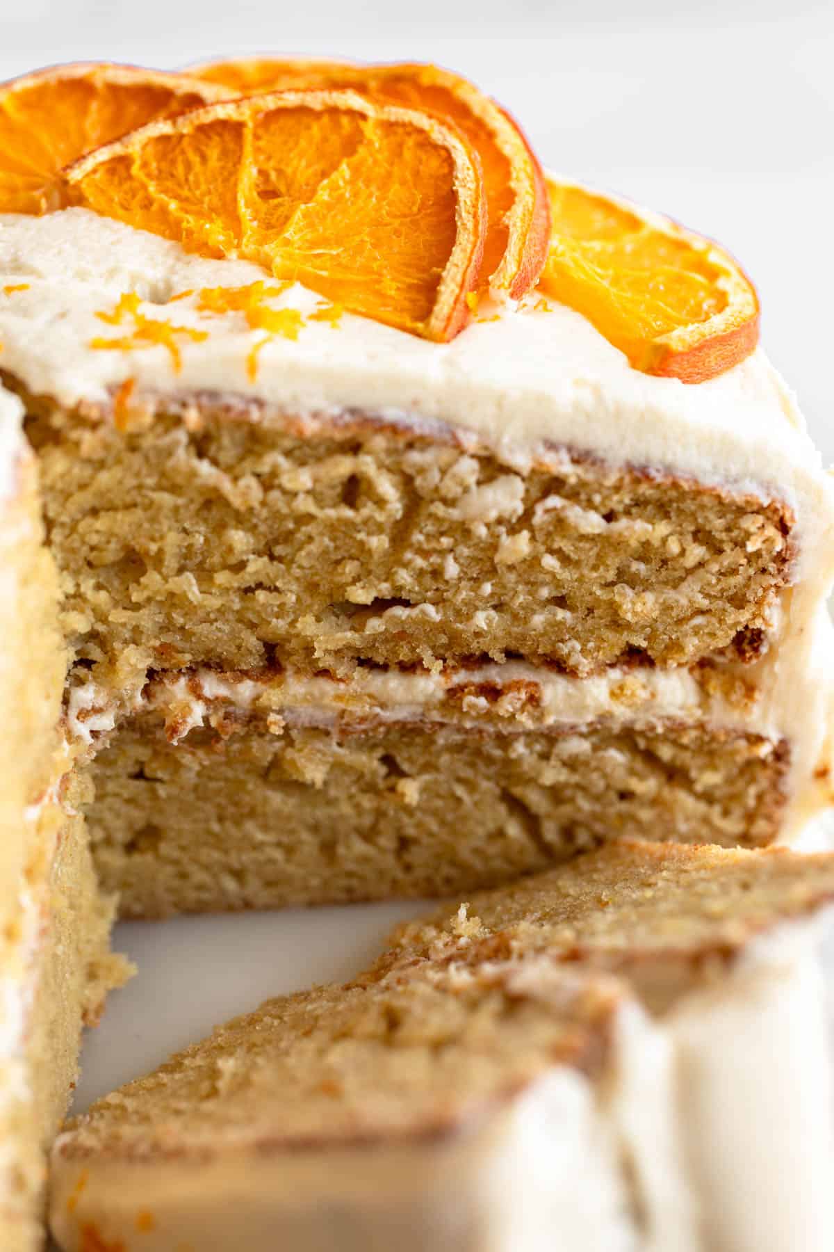gluten free orange cake on a cake stand with a slice