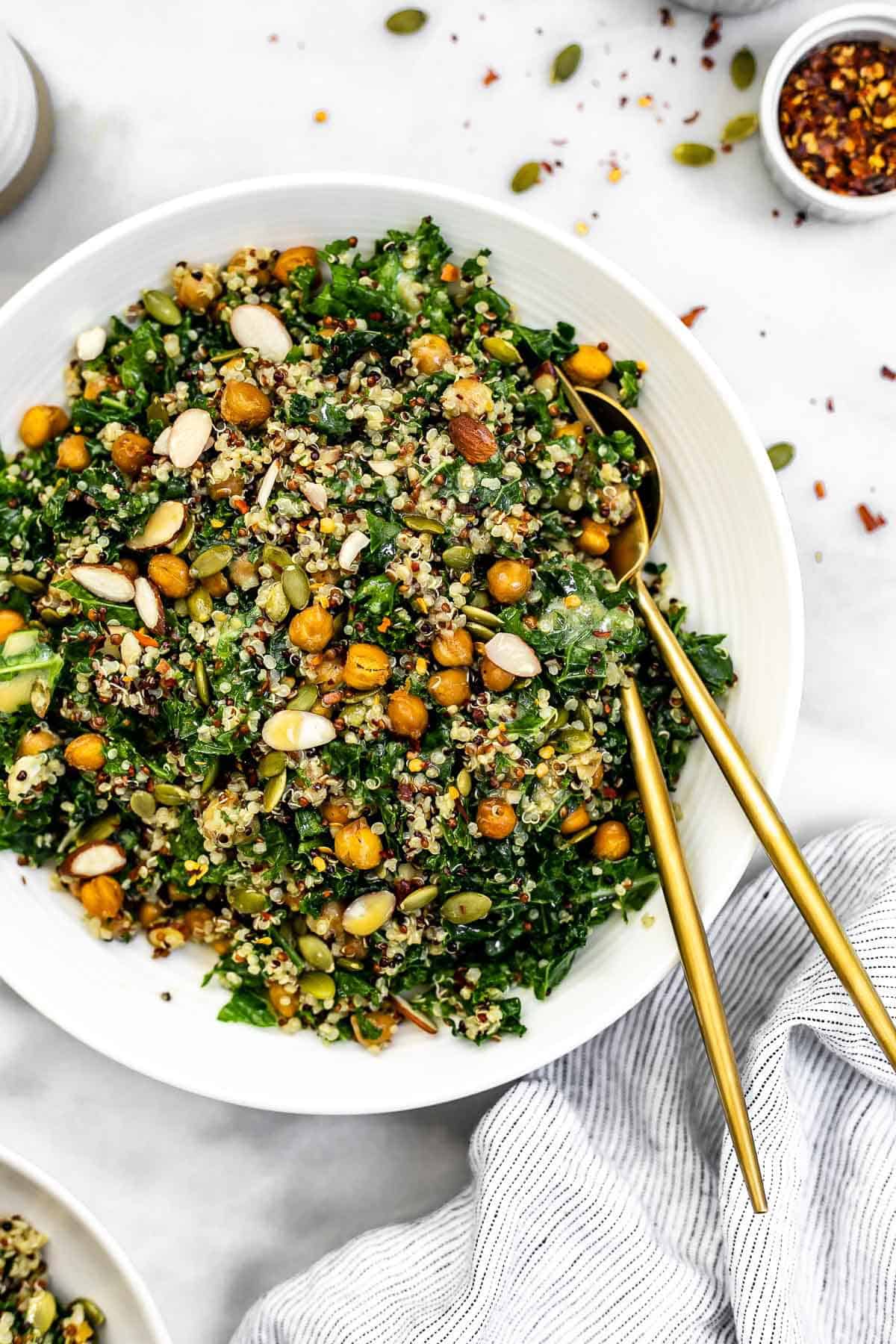 Kale quinoa salad with crispy garlic chickpeas in a white bowl. 