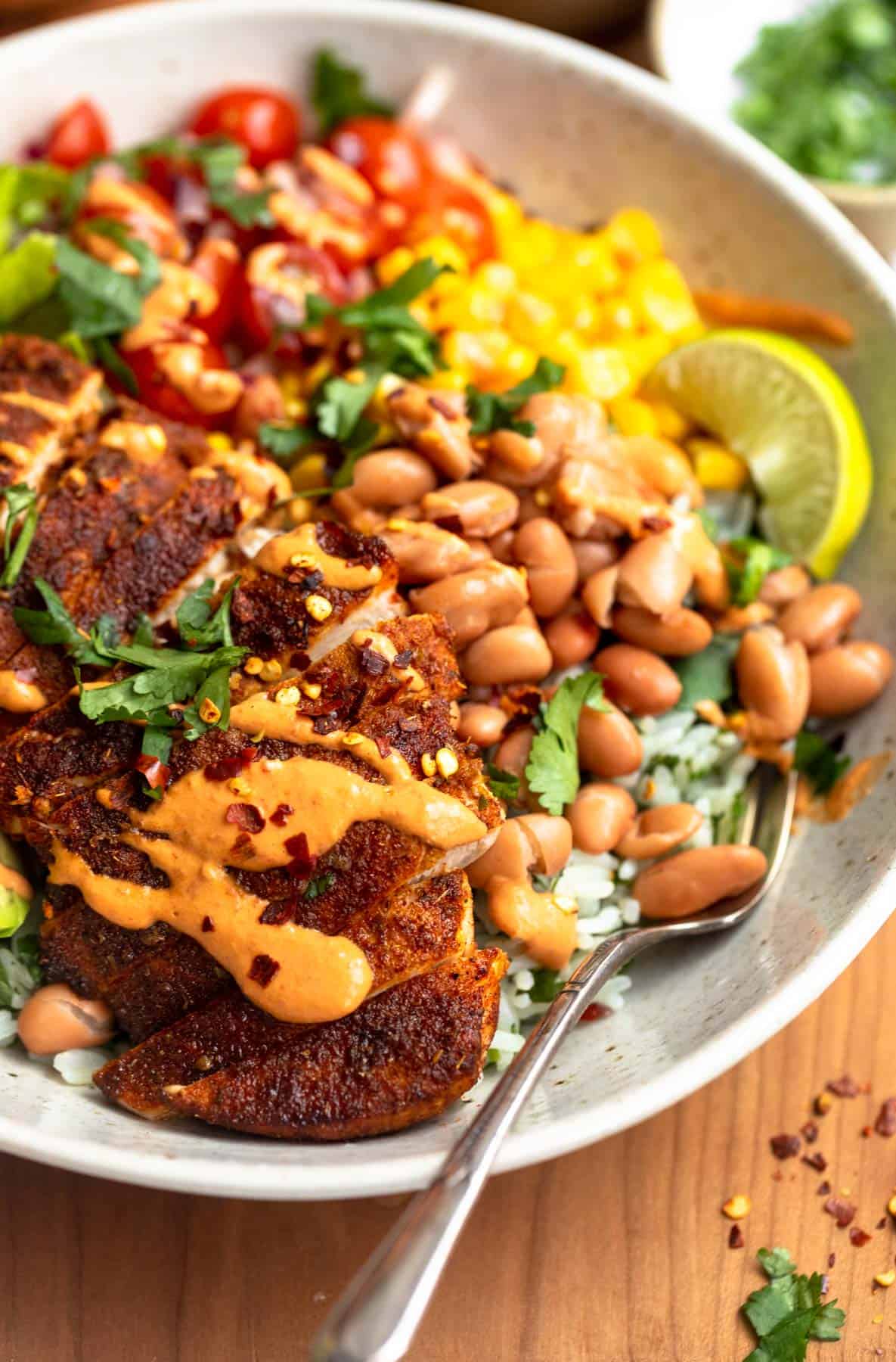 angled view of the chicken burrito bowl with a fork on the side