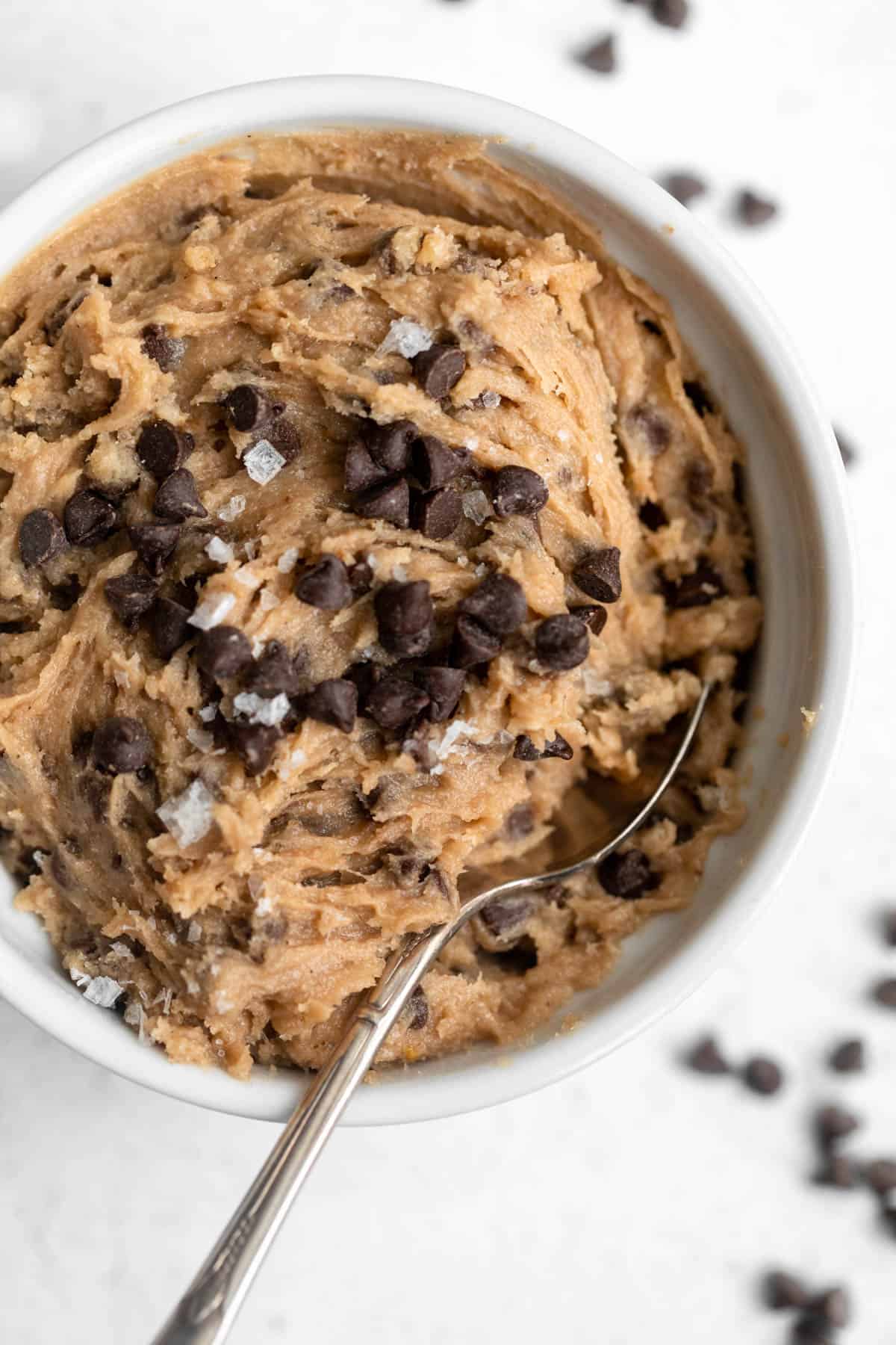 gluten free cookie dough in a bowl with a spoon on the side