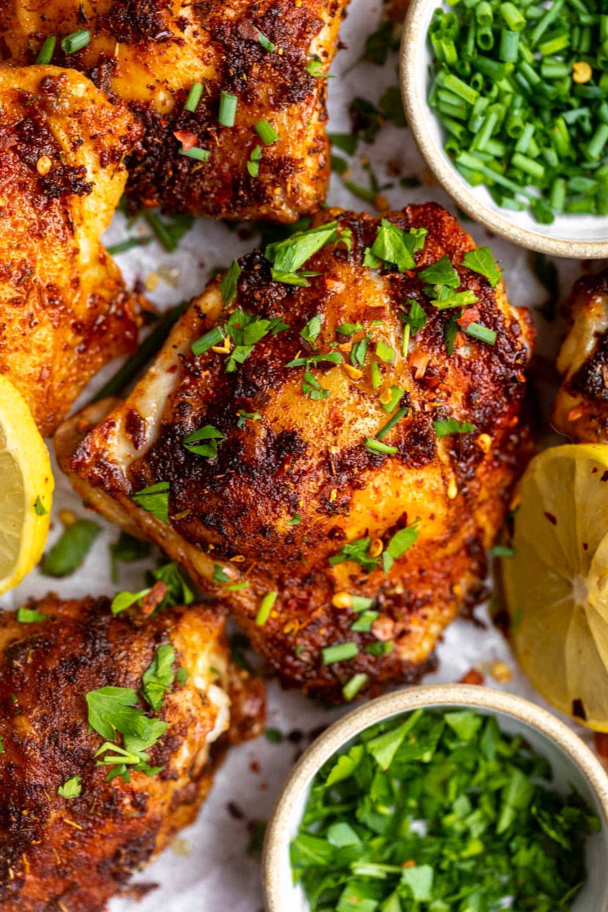 overhead shot of the chicken thighs on parchment paper with herbs