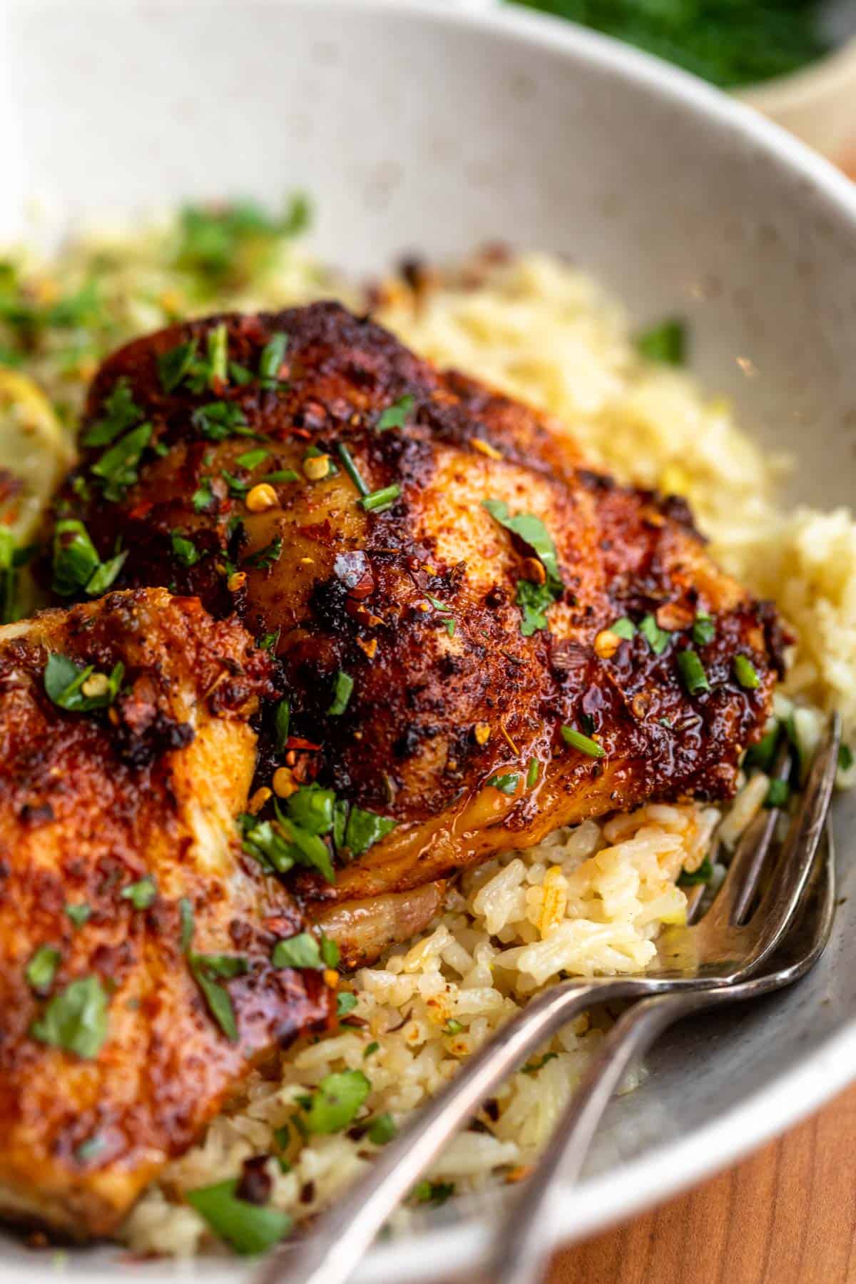 baked chicken thighs in a bowl with rice and herbs