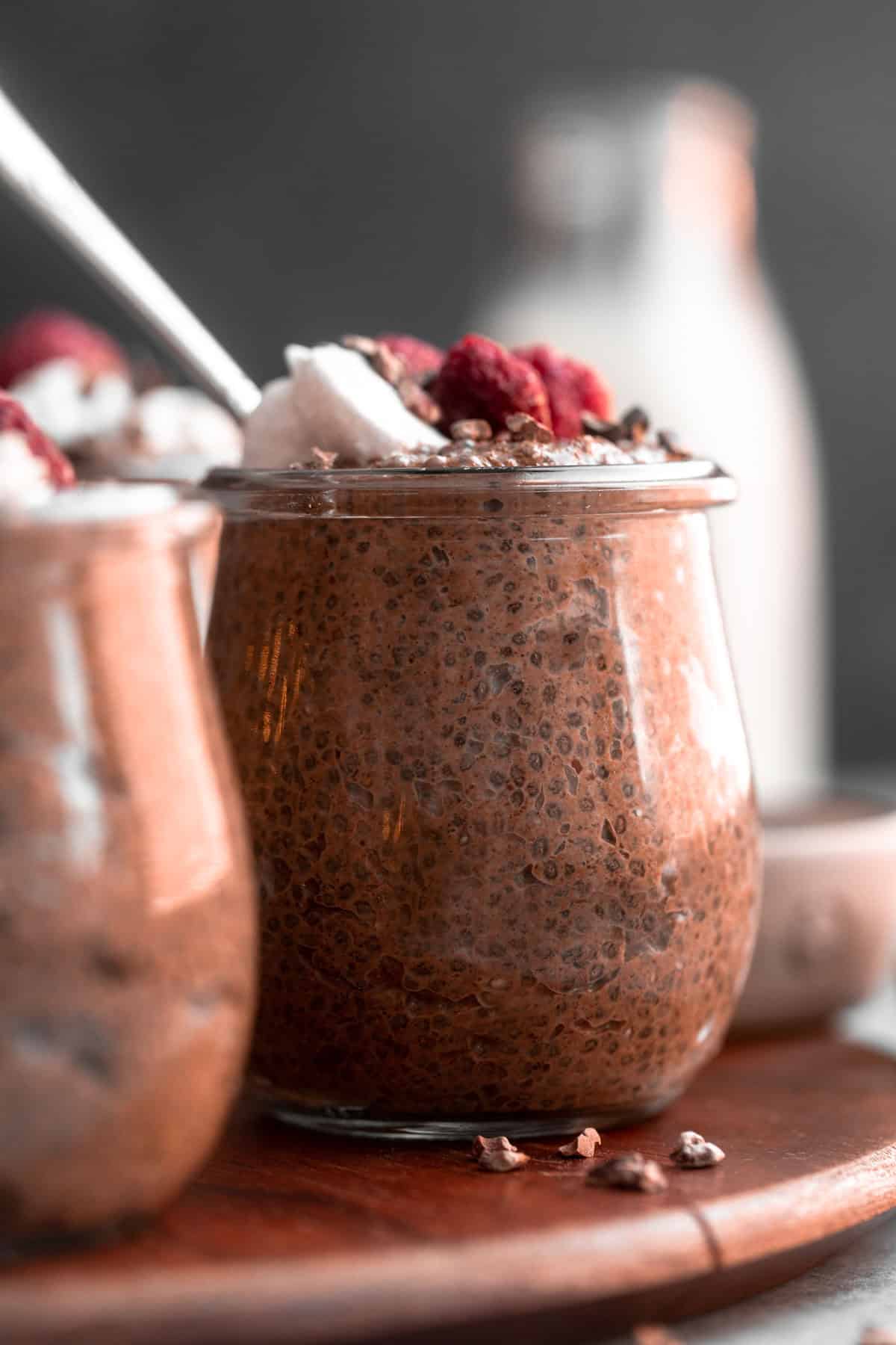 chocolate chia pudding in a glass jar with yogurt and berries on top
