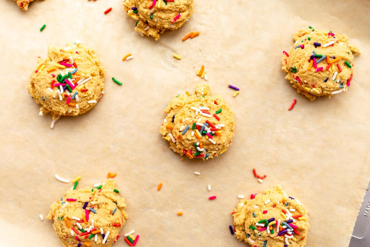 dough scooped into balls on a baking sheet before baking