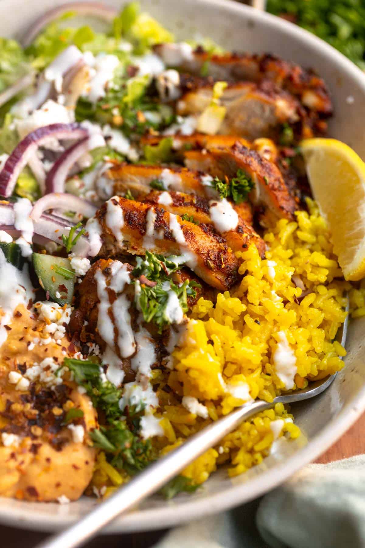angled view of the chicken shawarma bowl with turmeric rice and herbs