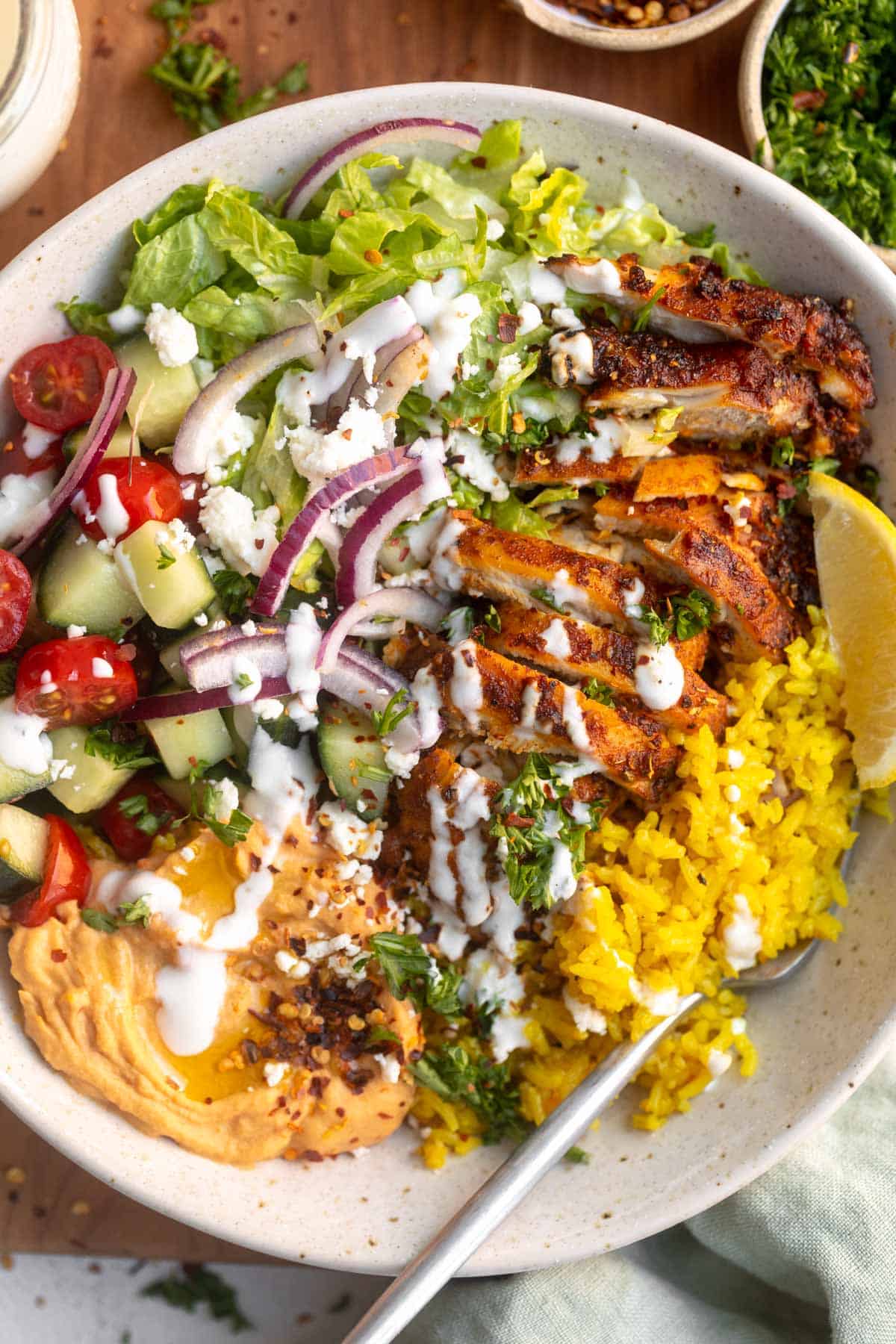 chicken shawarma bowl with turmeric rice, veggies and yogurt sauce