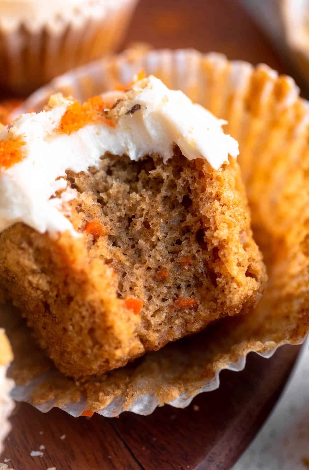 bite taken out of the gluten free carrot cake cupcake to show texture
