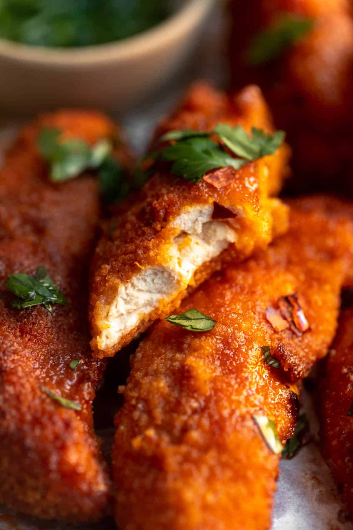 bite taken out of the buffalo chicken tender to show texture
