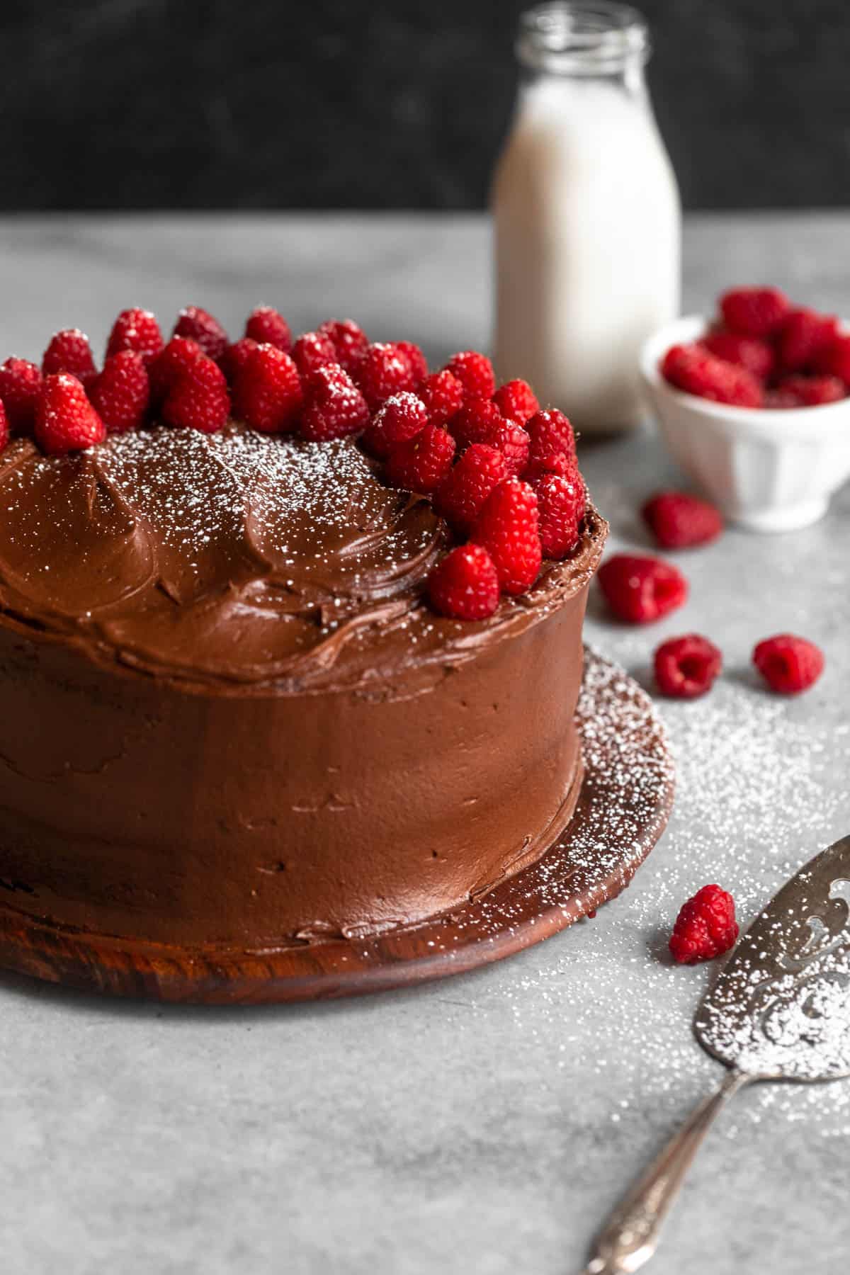raspberry chocolate cake on a cake stand with berries on top