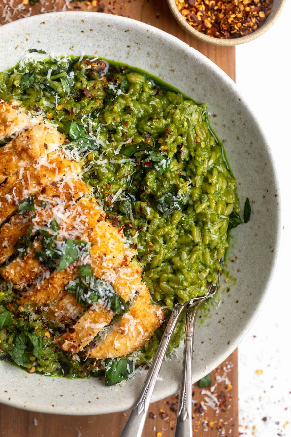 one pan orzo in a bowl with chicken cutlets on top