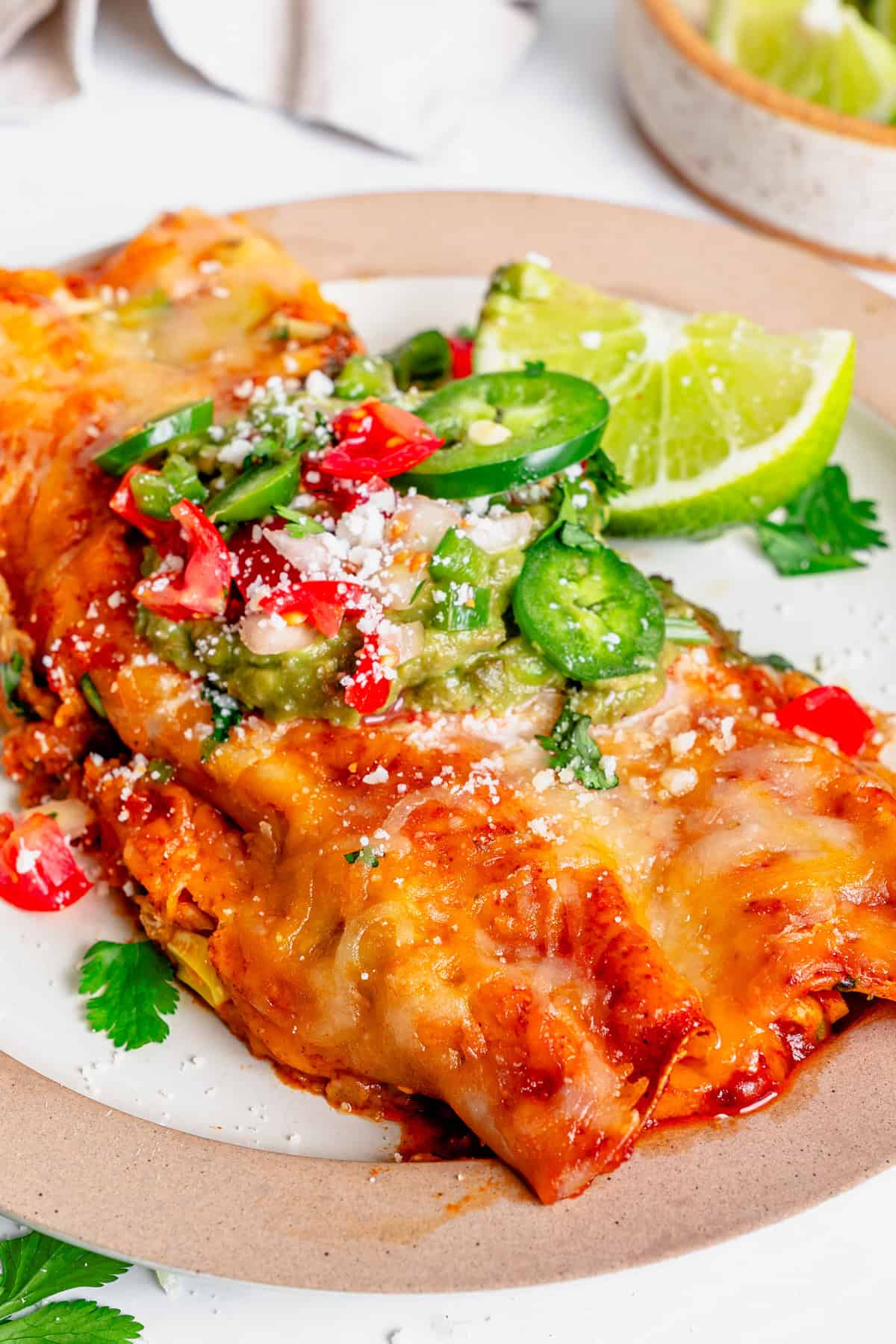 gluten free chicken enchiladas on a plate with cheese on toip