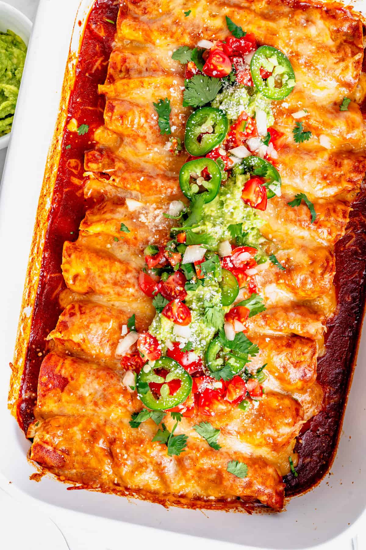 gluten free chicken enchiladas in a pan with herbs on top