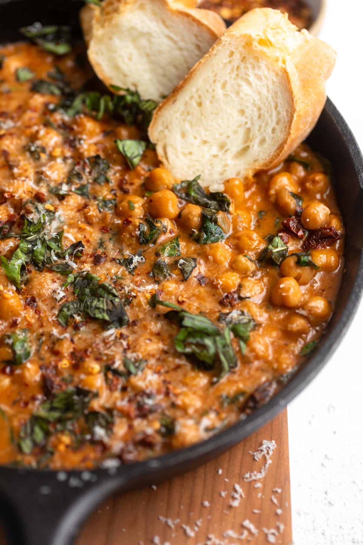 angled view of the marry me chickpeas in a skillet with basil 