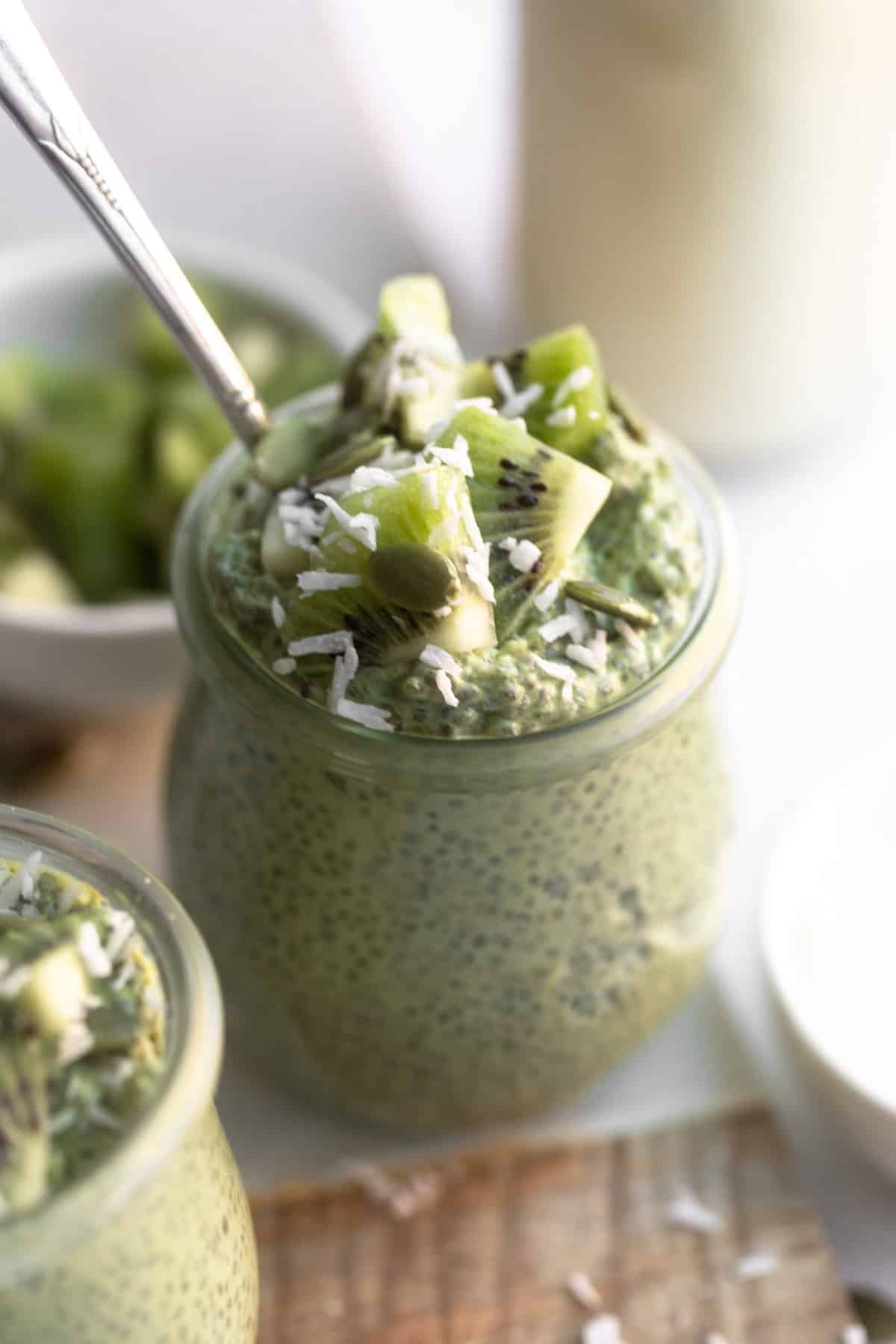 matcha chia pudding in a glass jar with kiwi 