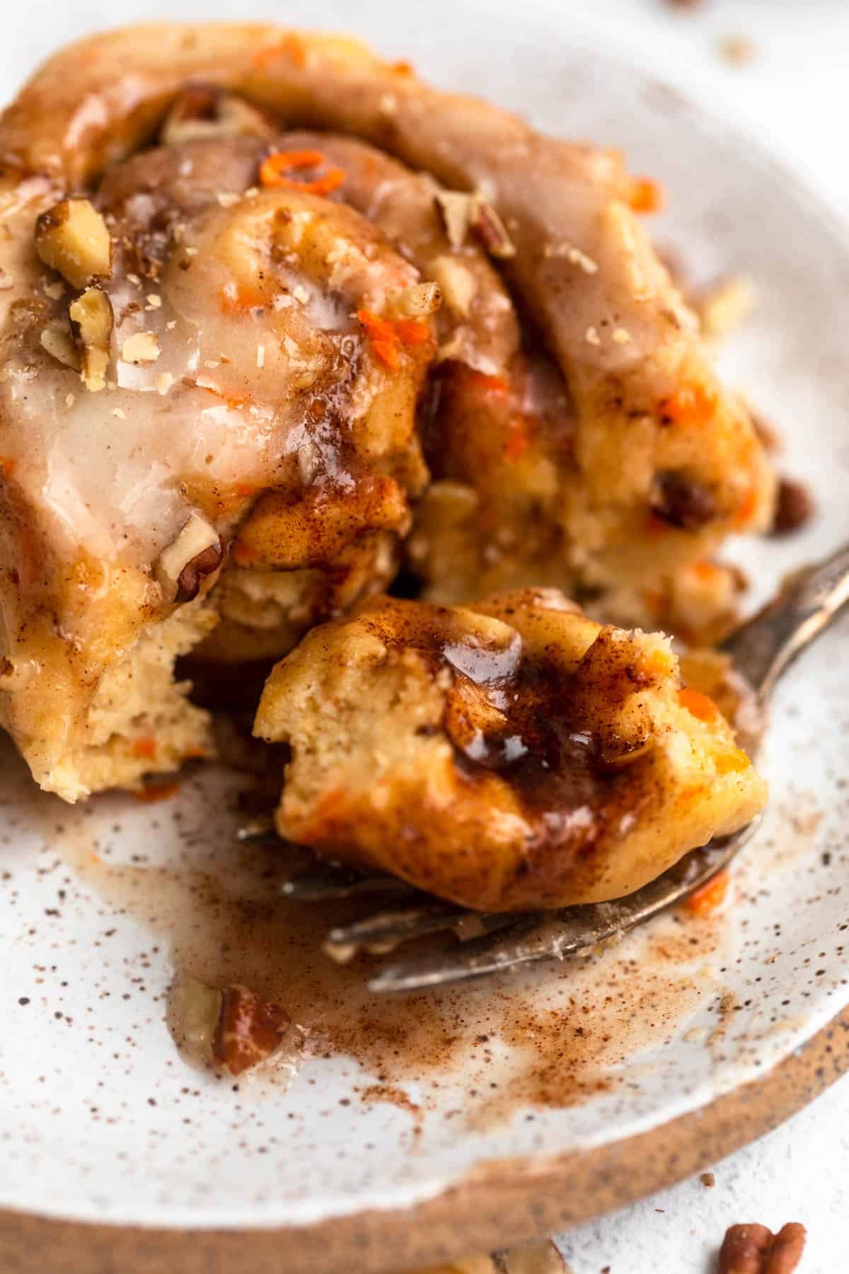 carrot cake cinnamon rolls with a bite taken out to show texture