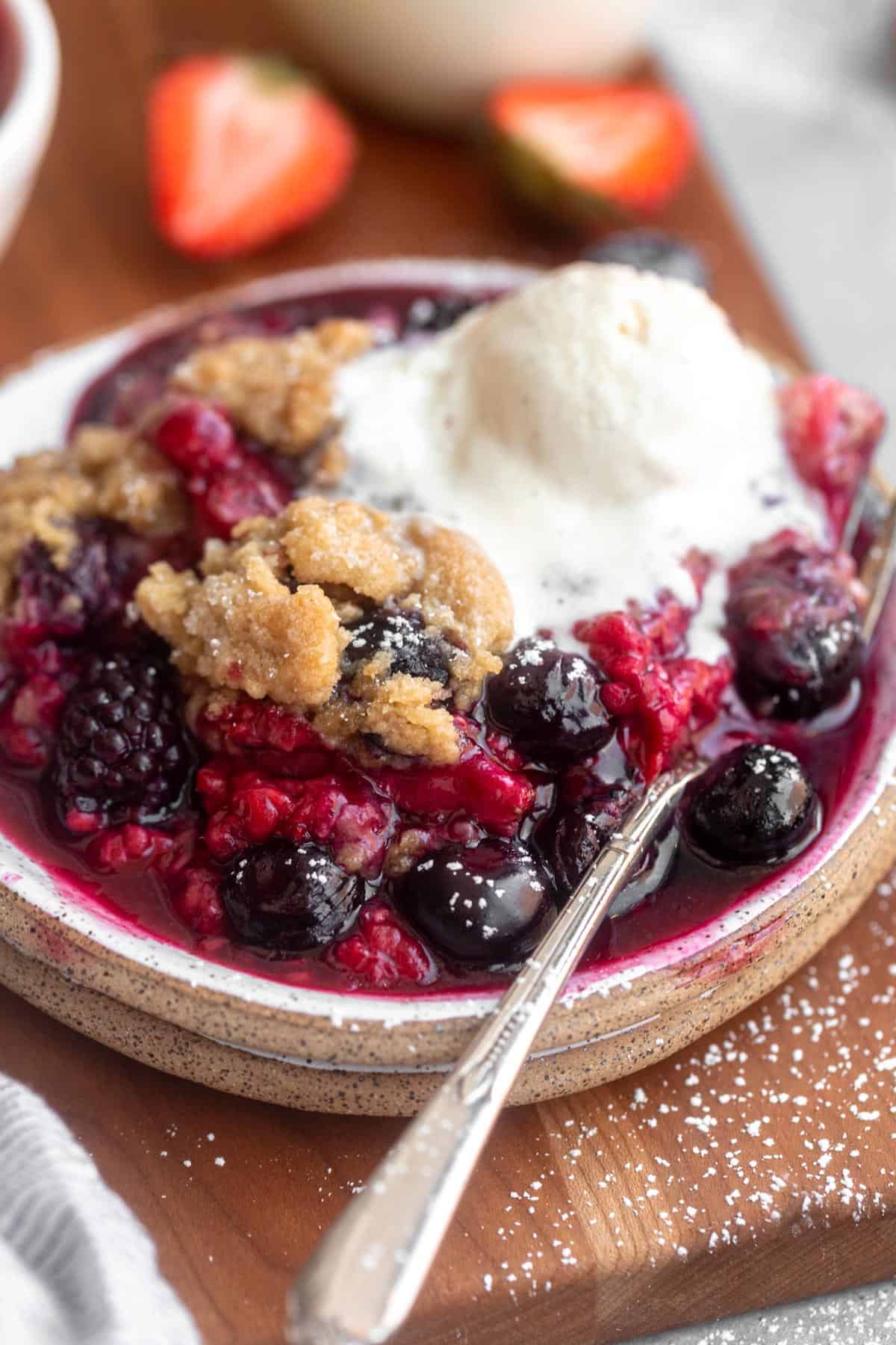 gluten free berry crumble on a plate with a fork on the side