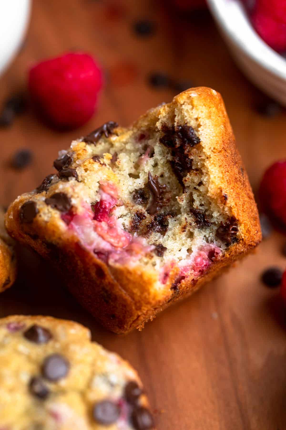 raspberry chocolate chip muffins with a bite taken out to show texture