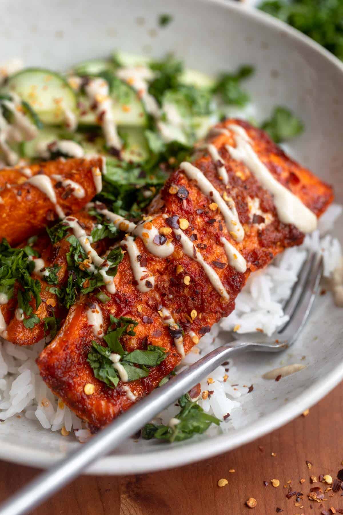 crispy harissa salmon bowl with a fork on the side