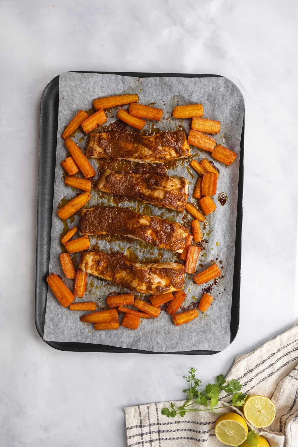 fish and carrots on the baking sheet after cooking