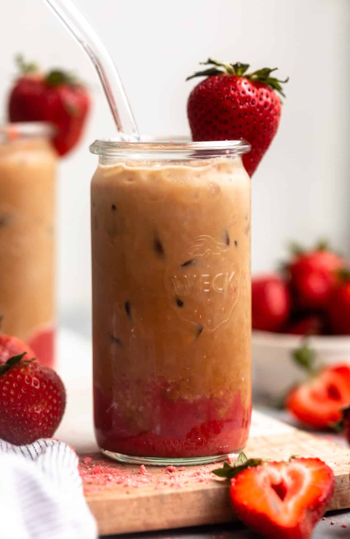 straight on view of the strawberry latte in a glass with a straw