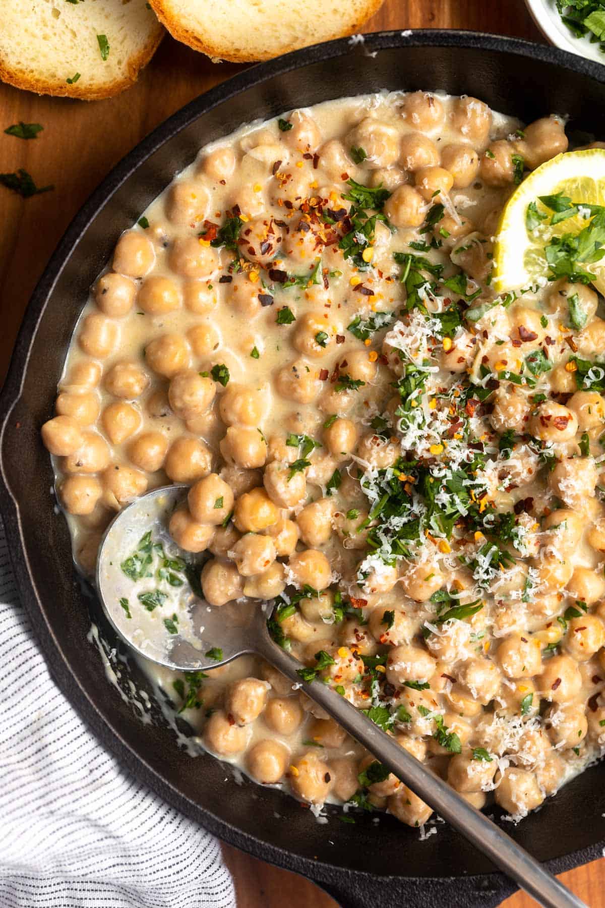 lemon pepper chickpeas in a skillet with a spoon on the side