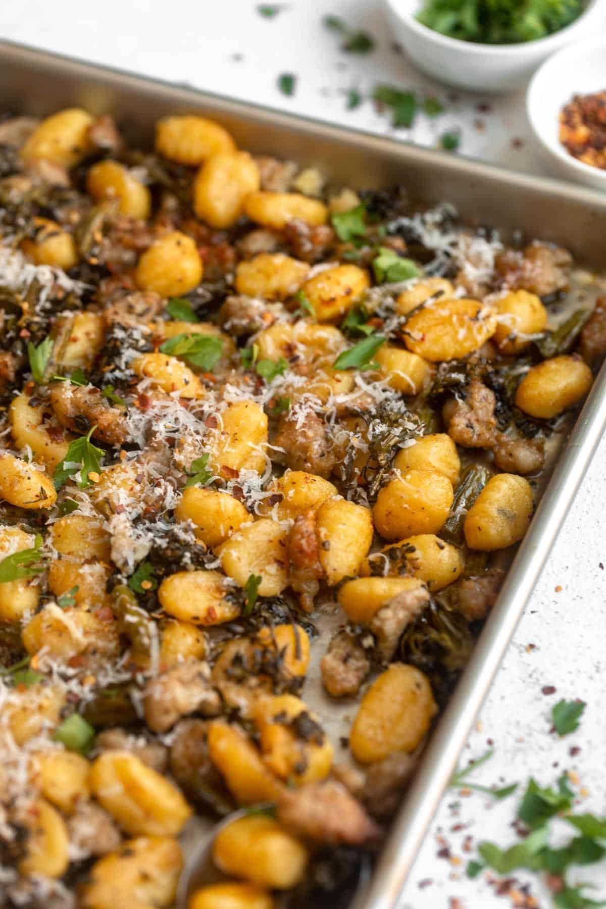 angled view of the sheet pan gnocchi with parmesan on top