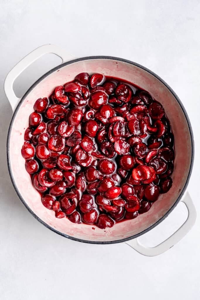 simmering the cherries in a pot on the stove