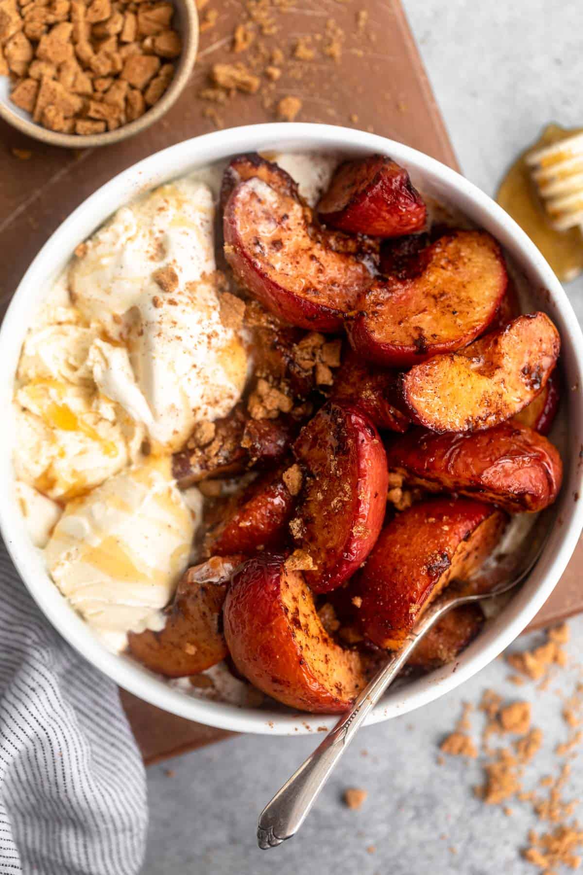 overhead shot of the air fryer peaches in a bowl with crushed graham crackers