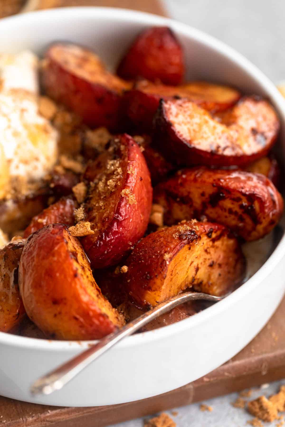 angled view of the air fryer peaches in a bowl with brown sugar