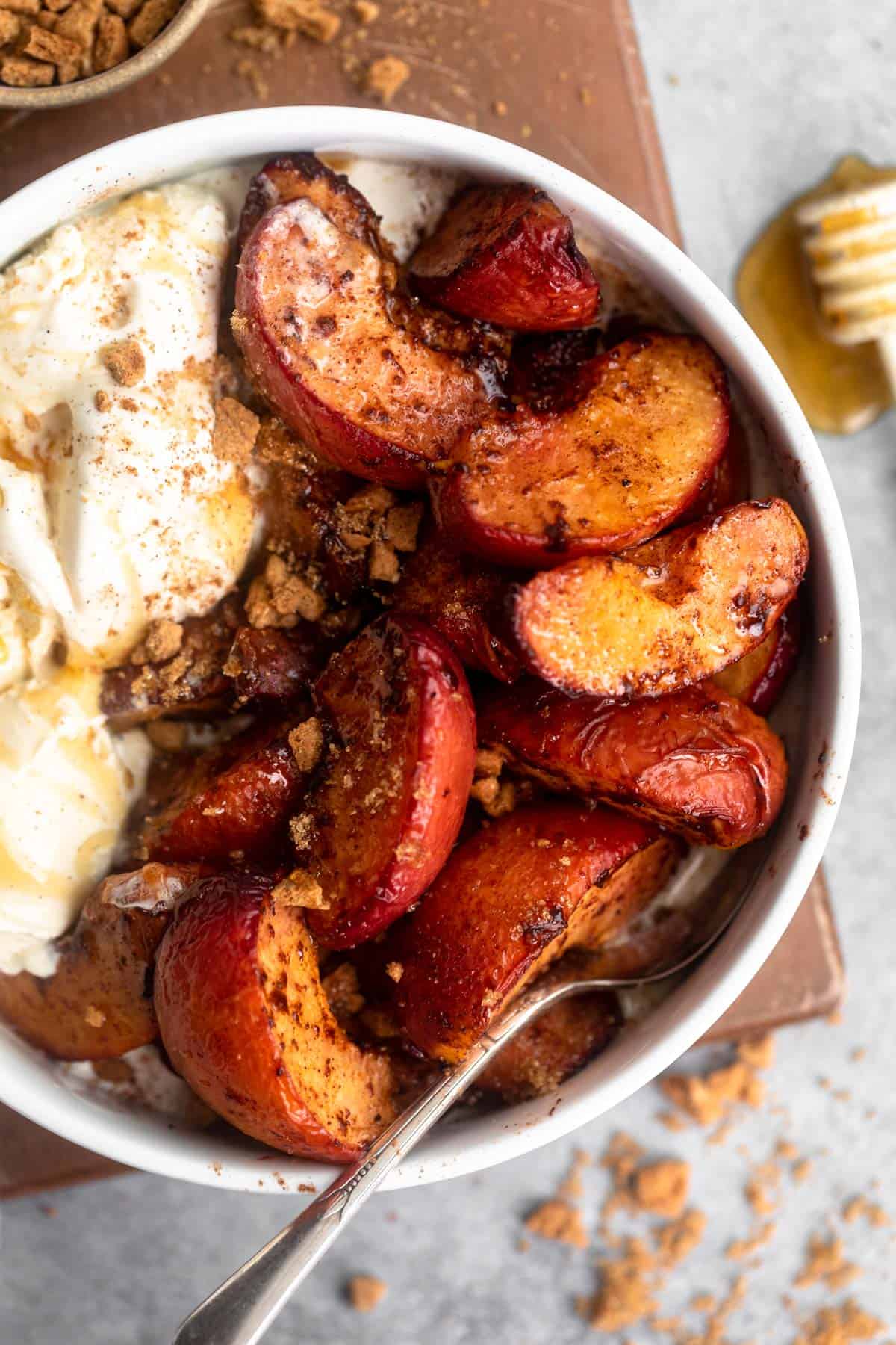 air fryer peaches in a bowl with vanilla ice cream