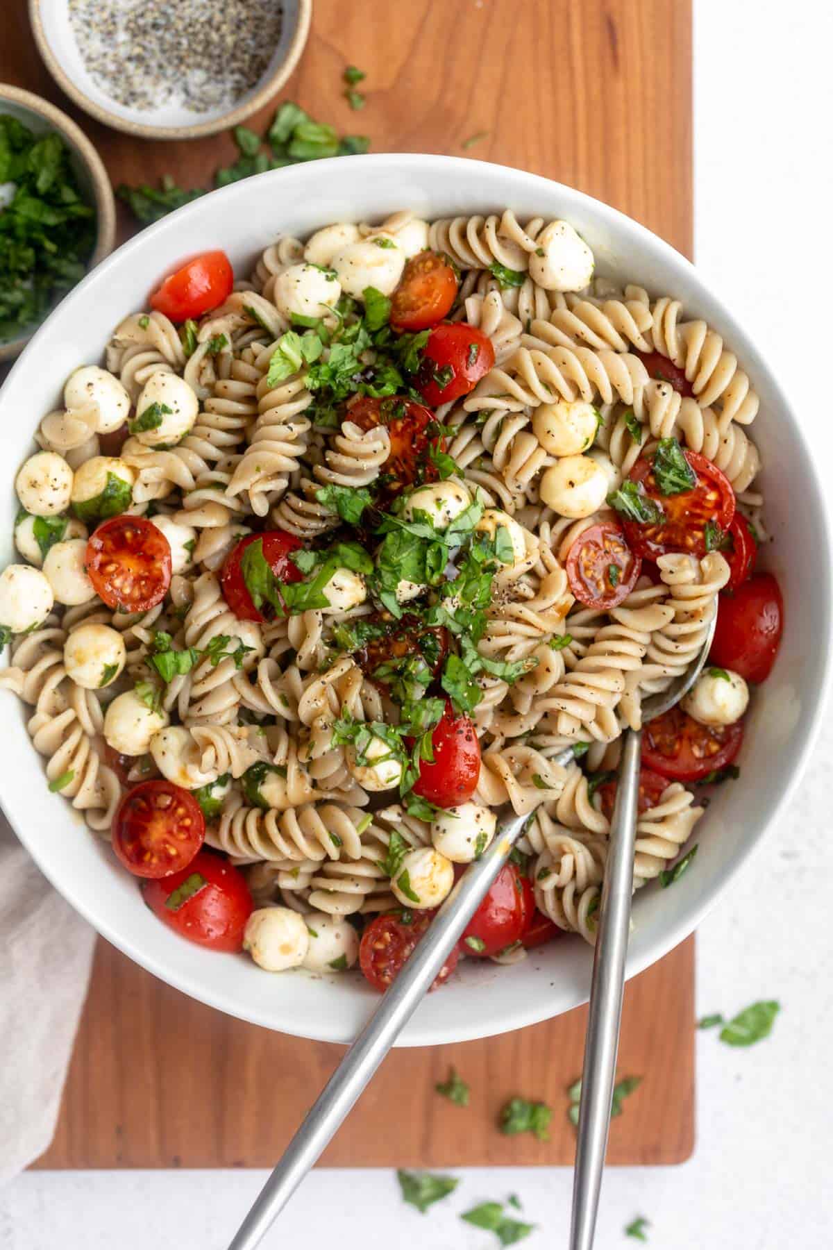 caprese pasta salad in a bowl with fresh basil