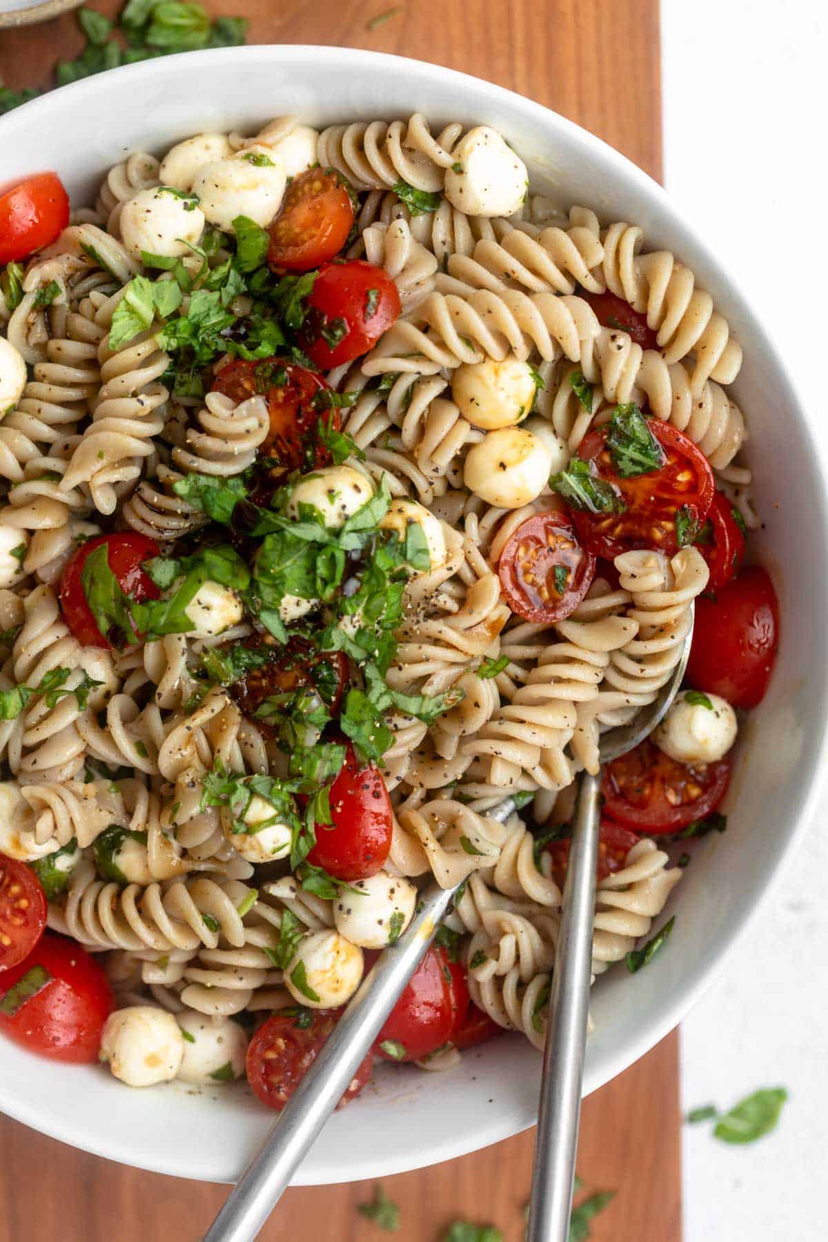 caprese pasta salad in a bowl with tomatoes and mozzarella
