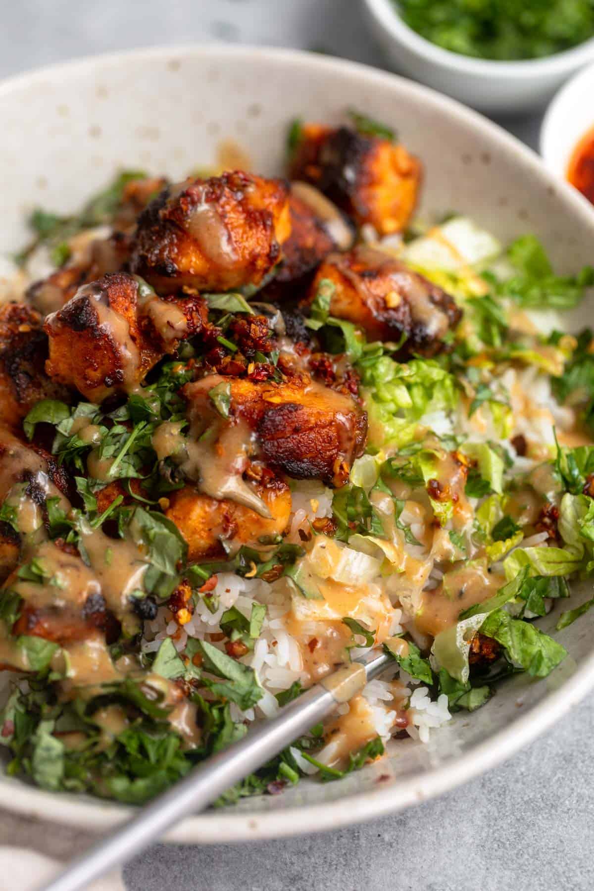 honey mustard salmon bites in a bowl with sauce on top