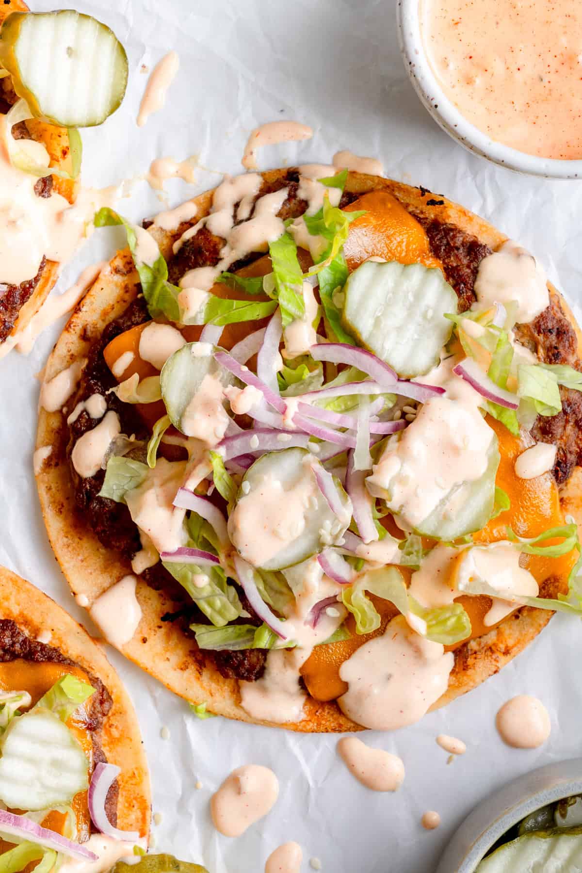 gluten free smashburger tacos on parchment paper with toppings