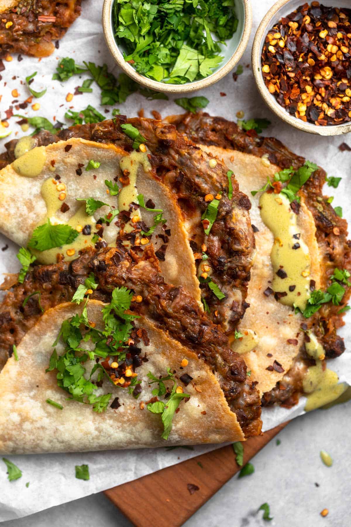overhead shot of three black bean tacos with cilantro and red pepper