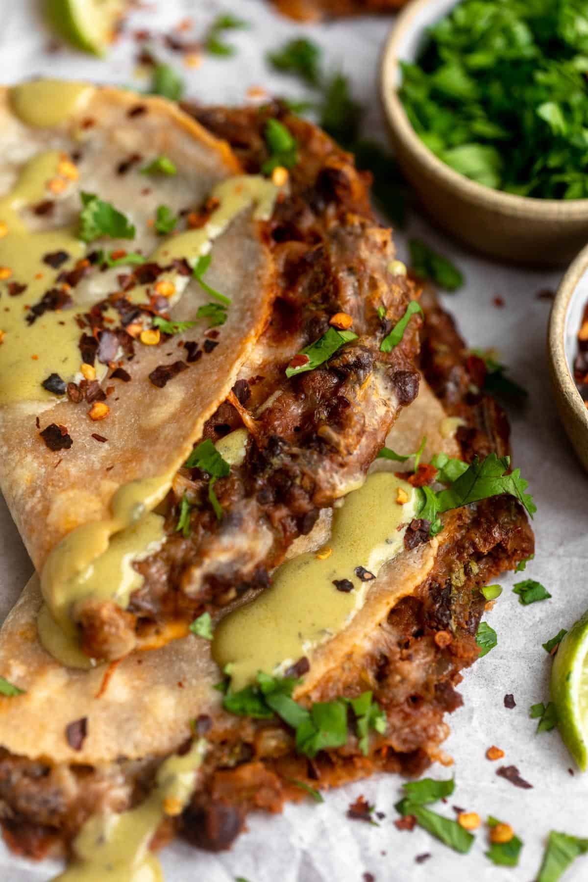 two black bean tacos stacked on each other with cilantro on top