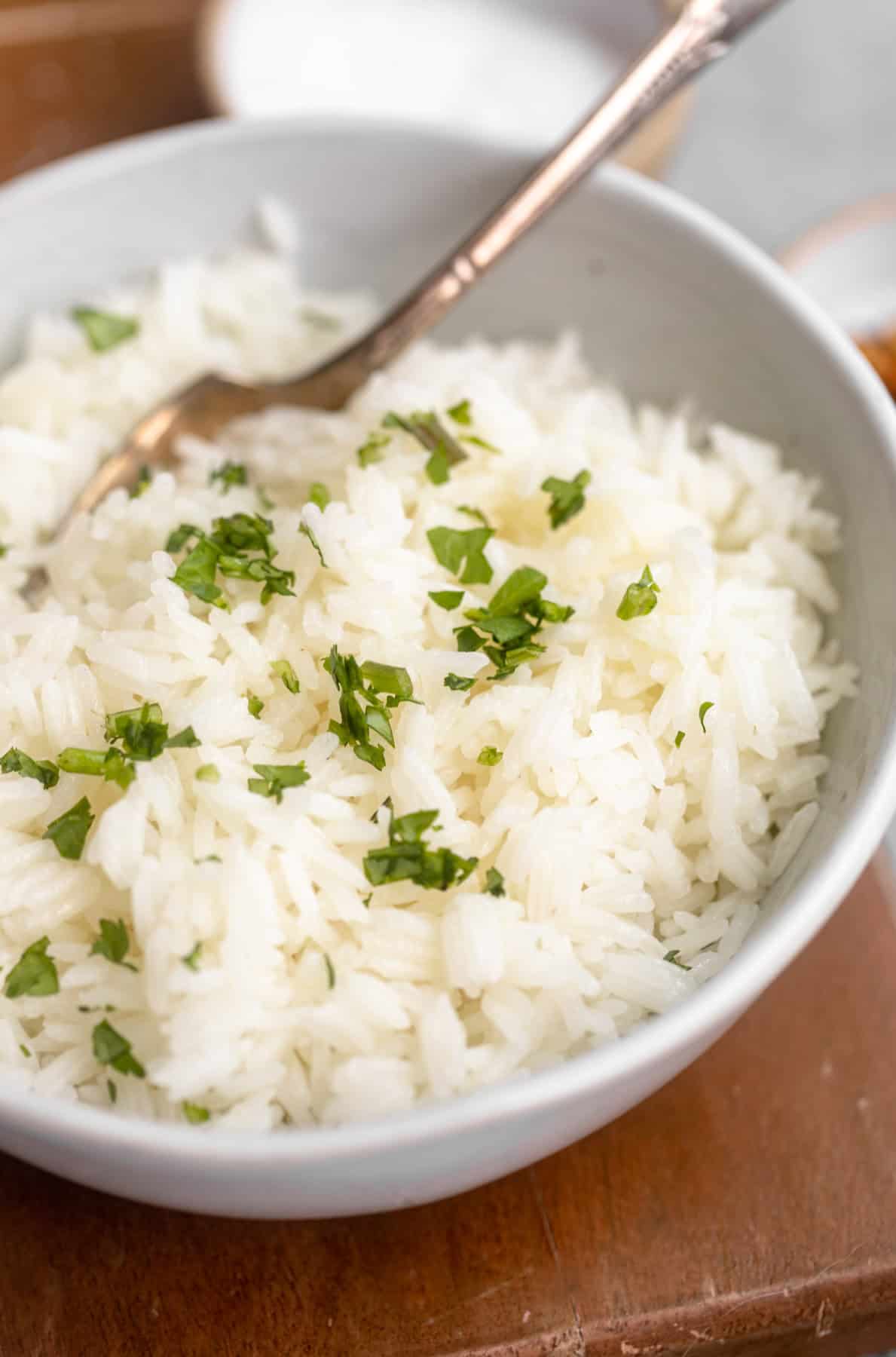 angled view of the jasmine rice in a bowl with herbs on top